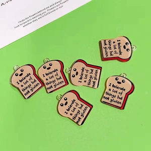 Detailed view of six acrylic toast pendants with funny slogans on a green background