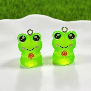Macro detail of cute luminous resin frog pendant with lollipop for DIY jewelry