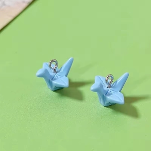 Close-up of light blue resin crane pendants with silver hooks for DIY jewelry making