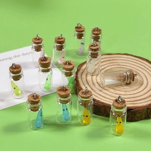 Detailed close-up of mini glass bottles with colorful resin ghosts for DIY jewelry crafts