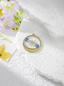 Détail macro du pendentif fleur séchée ronde avec accent en métal doré brossé