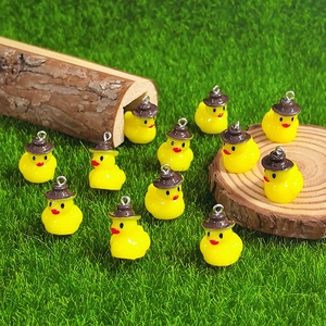 Detailed view of yellow resin ducks with hats for DIY jewelry and earring making