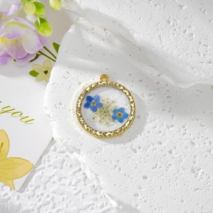 Pendentif rond en or avec myosotis bleus et fleurs séchées blanches en résine