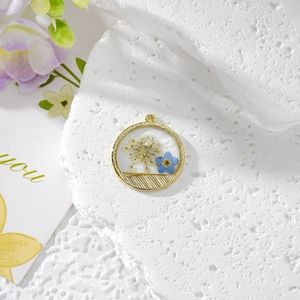 Pendentif rond doré avec fleurs de dentelle blanches et myosotis bleus pour bijoux DIY