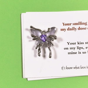 Silver liquid metal butterfly pendant with purple zircon on a poetic display card