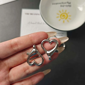 Macro shot of silver heart-shaped alloy lobster clasps for DIY jewelry and keychains