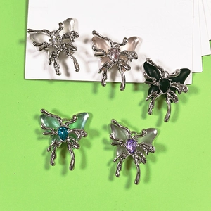 Macro detail of alloy butterfly pendants with colorful teardrop gems and frosted wings