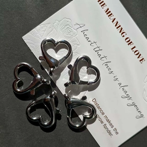 Five silver heart-shaped lobster clasps for DIY jewelry making on a stylish display card