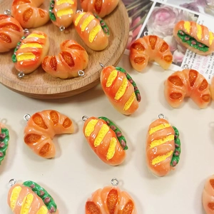 Detailed view of DIY resin charms featuring realistic croissants and sandwich pendants