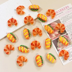 Detailed view of resin croissant and sandwich charms with silver metal pendant rings