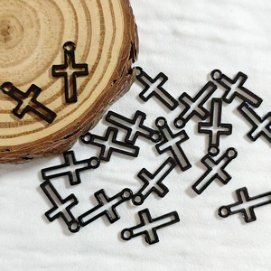 Detailed view of black alloy cross charms with top loop for DIY punk jewelry making