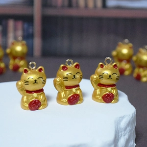 Detaillierte Ansicht von drei goldenen Maneki-Neko-Anhängern für DIY-Schmuck mit rotem Halsband