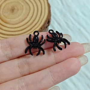 Close-up of black spider charm with glossy finish and loop for DIY jewelry making