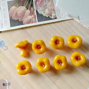 Close-up of 8 yellow resin mushroom pendants with metal loops for DIY jewelry making