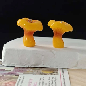 Macro detail of yellow resin mushroom charms showing realistic texture and metal rings