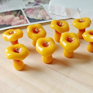 Macro detail of eight glossy yellow resin mushroom pendants with silver metal loops