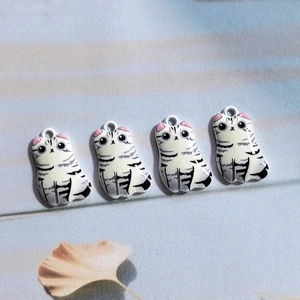 Vue détaillée de quatre breloques chat en alliage avec oreilles roses pour bijoux DIY