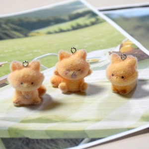 Detail of three cute flocked resin orange fox charms with soft texture and metal loops