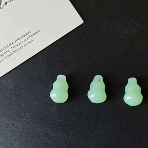 Detailed view of three light green resin gourd pendants on a black background for DIY jewelry