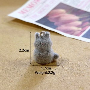 Close-up of grey flocked rabbit charm with size dimensions on wooden background