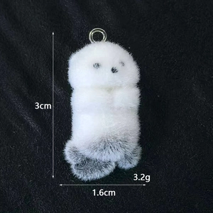 Dettaglio del ciondolo a forma di lontra bianca felpata di 3cm x 1,6cm e peso 3,2g