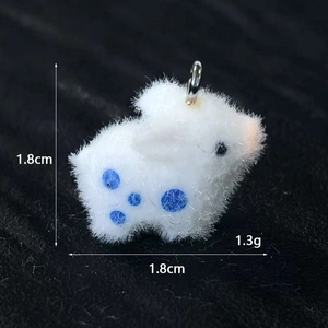 Macro di un ciondolo a forma di coniglio floccato bianco con puntini blu, 1,8cm e 1,3g