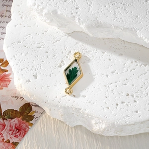 Détail macro du pendentif losange en résine avec vraie feuille verte et cadre doré
