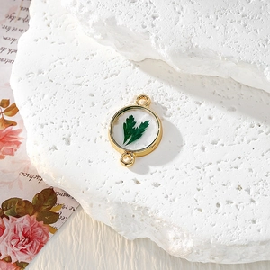 Détail macro d'un pendentif rond en alliage doré avec de vraies feuilles en résine