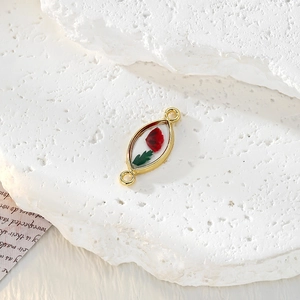 Dettaglio pendente marquise in lega dorata con vero fiore rosso essiccato in resina e asole
