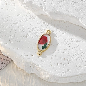 Dettaglio ciondolo ovale in lega dorata con fiore secco rosso in resina per gioielli DIY