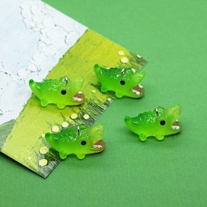 Macro-opname van schattige lichtgevende krokodilhangers van hars voor doe-het-zelf sieraden