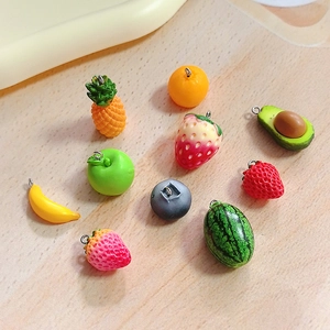 Flat lay of colorful resin fruit charms with metal rings for DIY jewelry making