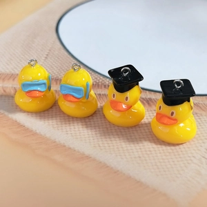 Detailed view of yellow resin duck charms with blue goggles and black doctor hats