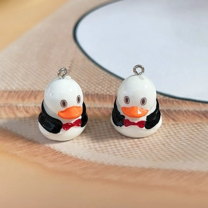 Detailed macro view of resin duck pendants with black suits for DIY jewelry and crafts