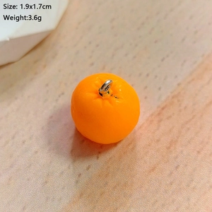 Macro view of 1.9x1.7cm orange fruit resin pendant with realistic peel texture detail