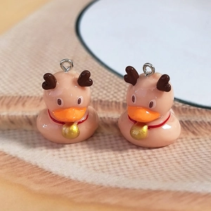 Detail of resin duck charms with reindeer antlers and golden bells for DIY jewelry