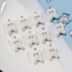 Macro shot of 10-piece set of cute resin tooth charms with pink blush and metal rings