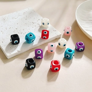 Gros plan de perles de dés œil grec colorées pour bijoux DIY sur surface en pierre