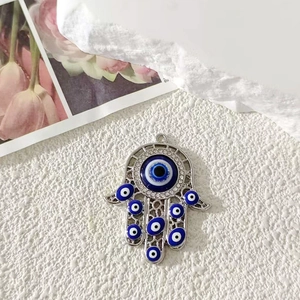 Vista macro del ciondolo Mano di Fatima con perle blu Evil Eye e intarsio di zirconi