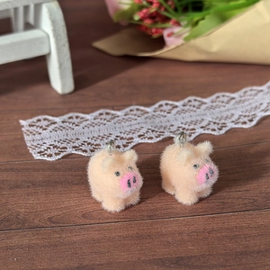 Detail of DIY flocking pink piglet charms with silver metal rings for jewelry making