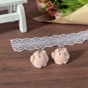 Macro shot of pink flocked pig pendants with silver rings for DIY jewelry making
