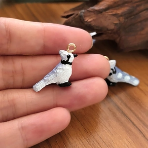 Handcrafted blue jay bird resin pendant for DIY jewelry making held in hand for scale