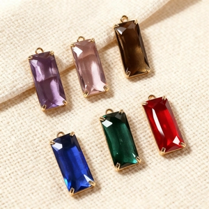 Macro view of colorful faceted crystal pendants with gold metal frames for DIY jewelry