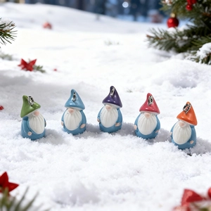 Detailed view of colorful resin Christmas gnome charms with metal rings on snowy background