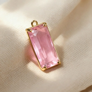Macro detail of rectangle pink crystal pendant with gold metal frame for DIY jewelry