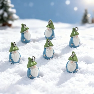 Macro view of cute resin Christmas gnome pendants with metal rings on snow background