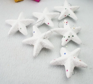 Detail view of 6-piece white foam Christmas stars with colorful sequins and silver lanyards