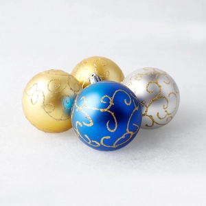 Macro shot of blue, gold, and silver Christmas ornaments with golden spiral glitter patterns