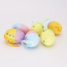 Close-up of sparkling colorful Easter foam eggs with glitter finish and hanging ribbons