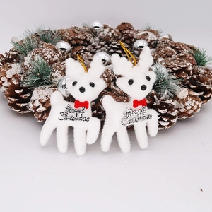 Two 11cm white flocked Christmas reindeer ornaments with red bows and Merry Christmas signs